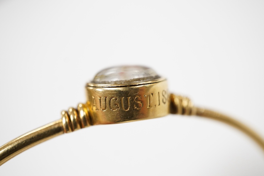 A regimental 'Essex Crystal' bangle, circa 1884, of hinged construction, collet-set with a reverse-carved and painted intaglio depicting the burgee of the Royal Yacht Squadron, mounted in gold, inscribed 'ER August 1884'